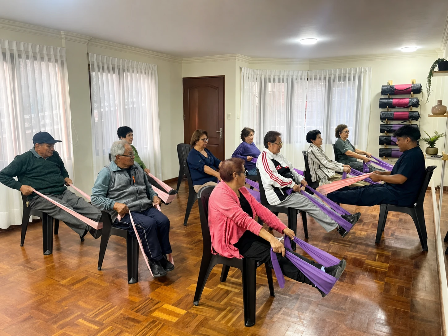 Personas mayores realizando ejercicios físicos adaptados con bandas